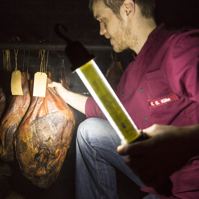 Kay Kühn holt Katenschinken aus der Räucherkammer, Landschlachterei Kühn, Oldenswort,